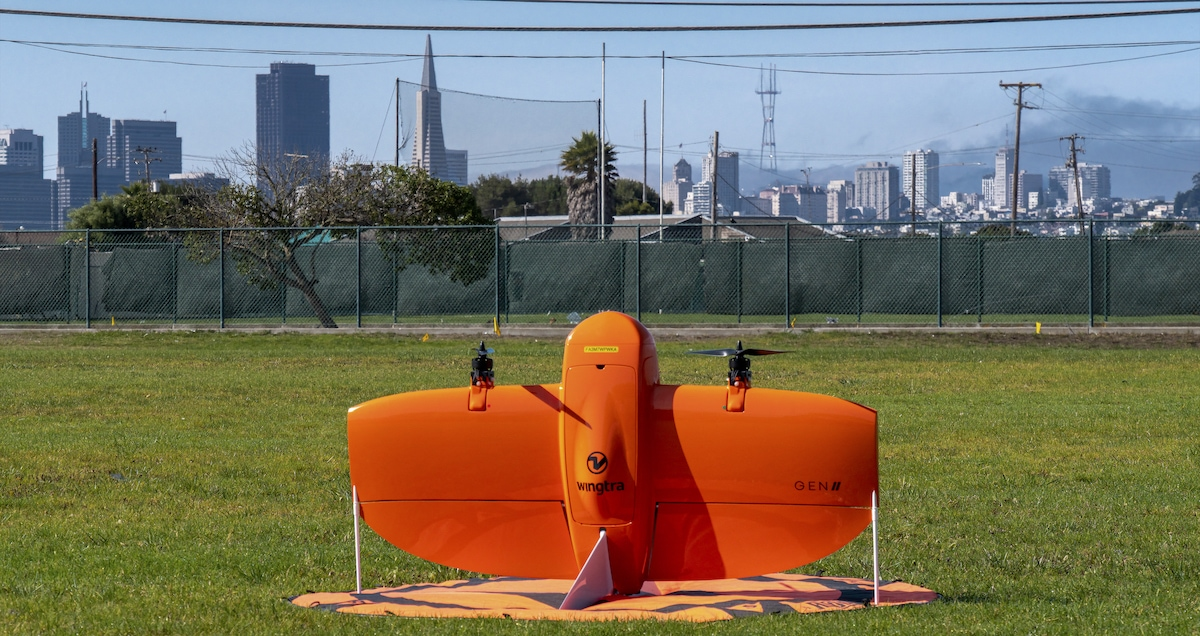 WingtraOne GEN II orange mapping drone standing upright on a field
